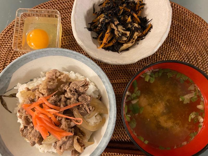 A hearty Japanese meal featuring gyudon (beef bowl), hijiki seaweed, and miso soup.